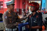 Petugas satlantas memberikan jas hujan sebagai apresiasi kepada siswa yang tertib berlalulintas saat sosialisasi dan penindakan terhadap pengguna knalpot motor modifikasi (brong) di salah satu SMK di Blitar, Jawa Timur, Kamis (27/11/2025). Satlantas Polres Blitar melakukan sosialsiasi sekaligus pemusnahan knalpot motor modifikasi dilingkungan sekolah guna mencegah balap liar yang sering melibatkan siswa tingkat SMA dan SMK, dalam rangka Operasi Zebra Semeru 2025. Antara Jatim/Irfan Anshori/um