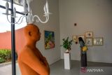 Pengunjung mengamati karya seni lukisan pada pameran seni yang bertajuk Ngariung di Galeri Seni Dot Hub dan Dia.Lo.Gue Artspace di Bandung, Jawa Barat, Sabtu (29/11/2025). Pameran yang menampilkan puluhan karya lukisan, instalasi, seni visual, dan patung karya 83 seniman dari berbagai daerah di Indonesia itu dalam rangka peresmian galeri seni baru Dot Hub dan Dia.Lo.Gue.Artspace serta ajang bagi seniman dari berbagai genre untuk berkumpul dan berdiskusi. ANTARA FOTO/Raisan Al Farisi/agr