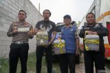 Petugas menunjukkan tiga jeriken sampel solar diduga ilegal dari truk tangki yang menjadi barang bukti kecelakaan lalu lintas di Jalur Lintas Selatan Tulungagung, Jawa Timur, Jumat (28/11/2025). Polisi mengambil sampel solar dari truk tangki yang mengalami kecelakaan tunggal di JLS itu, untuk diperiksa di Puslabfor Polri dan Sucofindo karena tidak disertai kelengkapan surat angkut BBM dan diduga terkait penyalahgunaan solar subsidi untuk kepentingan industri. ANTARA Jatim/Destyan Sujarwoko/mas.