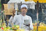 Pemuka agama Hindu memercikkan air suci saat persembahyangan bersama Hari Raya Kuningan di Pura Sakenan, Denpasar, Bali, Sabtu (29/11/2025). Hari Raya Kuningan dirayakan Umat Hindu sebagai rangkaian dari Hari Raya Galungan yaitu perayaan kemenangan kebenaran (dharma) atas kejahatan (adharma). ANTARA FOTO/Fikri Yusuf/wsj.