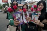 Penggiat HIV/AIDS membagikan bunga mawar dan leaflet kepada pengguna jalan di Tulungagung, Jawa Timur, Senin (1/12/2025). Aksi simpati dalam rangka Hari AIDS Sedunia itu digelar untuk meningkatkan kesadaran masyarakat mengenai bahaya HIV/AIDS serta mendorong kelompok berisiko tinggi melakukan pemeriksaan dini di layanan kesehatan. ANTARA Jatim/Destyan Sujarwoko/mas.