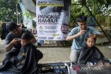 Kapster mencukur rambut anak-anak saat aksi sosial pangkas rambut bayar seikhlasnya di Alun-alun Ahmad Yani, Kota Tangerang, Banten, Minggu (30/11/2025). Aksi yang dilakukan oleh 15 kapster alumni Balai Latihan Kerja Kota Tangerang tersebut untuk mengumpulkan dana bantuan yang hasilnya akan disumbangkan bagi korban bencana alam di Aceh, Sumatera Utara dan Sumatera Barat. ANTARA FOTO/Putra M. Akbar/gp