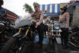 Kasat Lantas Polres Kediri Kota AKP Tutud Yudho Prastyawan (kiri) didampingi Kasi Humas Iptu Sundari (kanan) melakukan pengecekan sejumlah sepeda motor yang diamankan hasil Operasi Zebra Semeru 2025 di Polres Kediri Kota, Kota Kediri, Jawa Timur, Selasa (2/12/2025). Operasi Zebra Semeru 2025 yang diselenggarakan selama empat belas hari di wilayah hukum Polres Kediri Kota tersebut berhasil menindak 43.399 pelanggar lalu lintas sebagai upaya mengurangi angka kecelakaan di jalan raya. ANTARA Jatim/Prasetia Fauzani/mas.