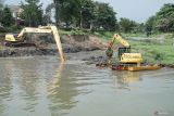 Pekerja mengoperasikan alat berat eksavator untuk mengeruk seimen di aliran Sungai Ngrowo, Tulungagung,  Jawa Timur, Selasa (2/12/2025). Normalisasi sungai dilakukan untuk mencegah pendangkalan yang berpotensi memicu banjir dalam kota saat penghujan. ANTARA Jatim/Destyan Sujarwoko/mas.