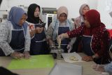 Peserta membuat jajanan pangsit bawang pada sesi praktik dalam kegiatan Pendampingan Wirausaha Industri Kecil Bidang Pengolahan Pangan di ruang Food Lab, Malang Creative Center, Jawa Timur, Rabu (3/12/2025). Program yang berlangsung selama empat hari itu diselenggarakan Kementerian Perindustrian dan diikuti 25 peserta yang merupakan ibu rumah tangga maupun pelaku Usaha Mikro Kecil Menengah (UMKM) sebagai upaya meningkatkan keterampilan serta kualitas produk olahan pangan. Antara Jatim/Ari Bowo Sucipto/um