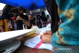 Sejumlah warga menunggu giliran pemeriksaan berat dan tinggi badan bayi di Posyandu Kencana, Desa Kuala Dua, Kecamatan Sungai Raya, Kabupaten Kubu Raya, Selasa (2/12/2025). Pemerintah Kabupaten Kubu Raya memperkuat pelayanan kesehatan dasar melalui optimalisasi 511 posyandu di sembilan kecamatan di daerah setempat untuk meningkatkan status gizi balita, mencegah stunting, dan memperluas layanan kesehatan ibu serta anak. ANTARA FOTO/Jessica Wuysang
