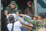 Pangdam XX/ Tuanku Imam Bonjol Mayjen TNI Arief Gajah Mada (kiri) menurunkan bantuan setibanya di Nagari Salareh Aia, Palembayan, Agam, Sumatera Barat, Selasa (2/12/2025). Kunjungan Pangdam yang disertai penyerahan bantuan ke kecamatan dengan 115 korban meninggal dan 76 korban hilang akibat banjir bandang tersebut bertujuan memastikan upaya percepatan pemulihan trauma, perbaikan infrastruktur, dan pencarian korban hilang pascabencana berjalan maksimal. ANTARA FOTO/Wahdi Septiawan/bar
