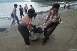 Dua siswa anggota pramuka menyeret karung berisi penuh sampah yang dipungut dari pesisir Pantai Cengkrong, Trenggalek, Jawa Timur, Kamis (4/12/2025). Aksi bersih pantai melibatkan pelajar itu digelar untuk menumbuhkan kesadaran lingkungan sekaligus mengurangi pencemaran kawasan pesisir akibat sampah yang terbawa arus laut maupun aktivitas wisata. ANTARA Jatim/Destyan Sujarwoko/mas.