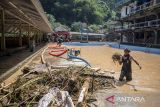 Warga membersihkan material lumpur dan sampah pascabanjir bandang di objek wisata Lembah Curugan Gunung Putri, Desa Mukapayung, Cililin, Kabupaten Bandung Barat, Jawa Barat, Jumat (5/12/2025). Bencana banjir yang terjadi pada Kamis (4/12) akibat meluapnya Sungai Cibitung tersebut menyebabkan sedikitnya lima hektar lahan persawahan rusak dan merendam objek wisata Lembah Curugan Gunung Putri serta kolam ikan milik BUMDes di kawasan itu. ANTARA FOTO/Abdan Syakura/agr