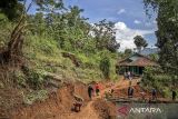 Warga memperbaiki jalan yang amblas pascalongsor di Desa Nanggerang, Cililin, Kabupaten Bandung Barat, Jawa Barat, Jumat (5/12/2025). Bencana tanah longsor yang terjadi pada Kamis (4/12) tersebut menyebabkan jalan yang menghubungkan Desa Nanggerang dengan Desa Mukapayung amblas dan tertutup material longsor sehingga hanya bisa dilalui oleh kendaraan roda dua secara bergantian. ANTARA FOTO/Abdan Syakura/agr
