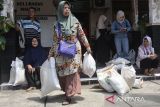 Keluarga Penerima Manfaat (KPM) membawa bantuan pangan di Kantor Kelurahan Maleber, Kabupaten Ciamis, Jawa Barat, Jumat (5/12/2025). Perum Bulog menyalurkan bantuan pangan periode Oktober - November 2025 sebanyak 20 kilogram beras medium dan empat kilogram MinyaKita untuk setiap KPM dengan total sasaran 18,2 juta penerima dan terealisasi penyaluran mencapai 18 persen atau 65.700 ton dari target 365.000 ton beras dan 73 juta liter minyak goreng. ANTARA FOTO/Adeng Bustomi/agr
