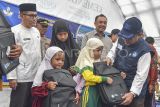 Menteri Pendidikan Dasar dan Menengah (Mendikdasmen) Abdul Muâti (kanan) menyerahkan bantuan kepada siswa di SMPN 1 Tanjung Raya, Agam, Sumatera Barat, Jumat (5/12/2025). Mendikdasmen menyerahkan bantuan kepada keluarga guru dan siswa terdampak bencana banjir dan longsor di daerah itu dan memberikan bantuan peningkatan mutu pendidikan berupa perangkat telekomunikasi. ANTARA FOTO/Wahdi Septiawan/rwa.
