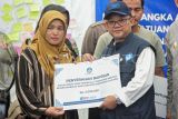 Menteri Pendidikan Dasar dan Menengah (Mendikdasmen) Abdul Muâti (kanan) menyerahkan bantuan kepada keluarga korban terdampak bencana banjir dan longsor di SMPN 1 Tanjung Raya, Agam, Sumatera Barat, Jumat (5/12/2025). Mendikdasmen menyerahkan bantuan kepada keluarga guru dan siswa terdampak bencana banjir dan longsor di daerah itu dan memberikan bantuan peningkatan mutu pendidikan berupa perangkat telekomunikasi. ANTARA FOTO/Wahdi Septiawan/rwa.