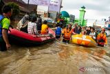 Petugas SAR gabungan membawa warga menggunakan perahu saat melintasi banjir di Jalan Raya Dayeuhkolot, Kabupaten Bandung, Jawa Barat, Sabtu (6/12/2025). Banjir yang terjadi di Kabupaten Bandung meluas hingga berdampak ke 14 kecamatan dengan volume air yang mengalami kenaikan 10cm hingga 50cm sehingga membuat Pemerintah Kabupaten Bandung menetapkan status tanggap darurat bencana banjir serta longsor dari 6 Desember hingga 19 Desember mendatang. ANTARA FOTO/Novrian Arbi/agr
