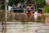Pelajar membawa tas untuk melintasi banjir di Baleendah, Kabupaten Bandung, Jawa Barat, Sabtu (6/12/2025). Banjir yang terjadi di Kabupaten Bandung meluas hingga berdampak ke 14 kecamatan dengan volume air yang mengalami kenaikan 10cm hingga 50cm sehingga membuat Pemerintah Kabupaten Bandung menetapkan status tanggap darurat bencana banjir serta longsor dari 6 Desember hingga 19 Desember mendatang. ANTARA FOTO/Novrian Arbi/agr
