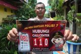 Anggota Polri menunjukkan stiker Call Center 110 Polrestabes Surabaya sebelum ditempelkan di Surabaya, Jawa Timur, Senin (8/12/2025). Polrestabes Surabaya mengerahkan seluruh Bhabinkamtibmas di Polsek jajarannya untuk melakukan sosialisasi dan penempelan stiker Call Center 110 di pusat perbelanjaan, perkampungan, fasilitas umum, sekolah dan lain-lain untuk mempermudah masyarakat menghubungi pihak kepolisian apabila memerlukan bantuannya. ANTARA Jatim/Didik Suhartono/mas.