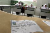 Siswa mengerjakan soal ujian Bahasa Indonesia dan IPA saat pelaksanaan Sumatif Akhir Semester (SAS) Jenjang SMP di SLB C (Autis) Kedungkandang, Malang, Jawa Timur, Selasa (9/12/2025). Sebanyak 155 siswa dari jenjang SD, SMP, hingga SMA di sekolah tersebut mengikuti SAS secara serentak dengan satu mata pelajaran tambahan, yakni Pengembangan Diri, dan dalam pelaksanaannya beberapa materi turut dipraktikkan untuk memudahkan siswa memahami soal ujian. Antara Jatim/Ari Bowo Sucipto/um