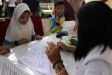 Dokter menuliskan resep obat untuk penyandang disabilitas tuna netra dalam kegiatan Pelayanan Kesehatan Gratis di SLB ABD Malang, Jawa Timur, Selasa (9/12/2025). Kegiatan yang melibatkan puluhan dokter dan relawan itu digelar dalam rangka memperingati Hari Disabilitas Internasional sebagai upaya meningkatkan akses layanan kesehatan sekaligus mendorong kesadaran masyarakat terhadap pentingnya pemeriksaan kesehatan rutin bagi penyandang disabilitas. ANTARA Jatim/Ari Bowo Sucipto/mas.