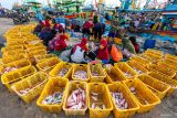 Sejumlah pekerja memindahkan ikan dari kapal menuju tempat pelelangan ikan di TPI Palang, Tuban, Jawa Timur, Rabu (10/12/2025). Pemda dan Penyelenggara Jaminan Sosial Ketenagakerjaan setempat menyepakati memberikan perlindungan lewat program jaminan sosial ketenagakerjaan kepada ribuan nelayan di kawasan itu guna mengurangi resiko kecelakaan kerja di laut. Antara Jatim/Muhammad Mada/um