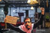 Seniman pantomim dari Mixi Imaji Mime Theater Andini Mardiani menampilkan gerakan pantomim dengan menggunakan topeng aktivis Munir Said Thalib saat peringatan Hari HAM Sedunia di Bandung, Jawa Barat, Rabu (10/12/2025). Peringatan Hari Ham Sedunia yang diadakan oleh Pusat Studi Mime Indonesia tersebut menghadirkan pameran arsip dan dokumentasi terkait perlawanan dan ketidakadilan serta penampilan seniman pantomim dari lintas disiplin ilmu. ANTARA FOTO/Raisan Al Farisi/agr