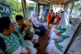 Sejumlah pelajar memanfaatkan fasilitas bus gratis untuk berangkat ke sekolah di Tuban, Jawa Timur, Kamis (11/12/2025). Fasilitas layanan angkutan gratis 'Si Mas Ganteng' sebanyak 20 unit mobil penumpang dan 20 unit bus itu disediakan oleh pemda setempat guna melayani kebutuhan transportasi masyarakat yang elegan, aman, nyaman, dan terintegrasi khususnya bagi pelajar SD, SMP, hingga SMA di wilayah tersebut. ANTARA Jatim/Muhammad Mada/mas.