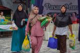 Warga membawa bahan pokok yang dibeli saat gelaran pasar murah di Balai Desa Jarit, Candipuro, Lumajang, Jawa Timur, Jumat (12/12/2025). Pemerintah Provinsi Jawa Timur menggelar pasar murah yang telah berlangsung sebanyak 290 kali sebagai upaya pengendalian inflasi dan stabilisasi harga kebutuhan pokok menjelang perayaan Natal dan Tahun Baru 2026. ANTARA Jatim/Irfan Sumanjaya/mas.