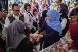 Gubernur Jawa Timur Khofifah Indar Parawansa (kanan) membagikan telur gratis saat gelaran pasar murah di Balai Desa Jarit, Candipuro, Lumajang, Jawa Timur, Jumat (12/12/2025). Pemerintah Provinsi Jawa Timur menggelar pasar murah yang telah berlangsung sebanyak 290 kali sebagai upaya pengendalian inflasi dan stabilisasi harga kebutuhan pokok menjelang perayaan Natal dan Tahun Baru 2026. ANTARA Jatim/Irfan Sumanjaya/mas.