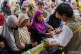 Warga membeli bahan pokok saat gelaran pasar murah di Balai Desa Jarit, Candipuro, Lumajang, Jawa Timur, Jumat (12/12/2025). Pemerintah Provinsi Jawa Timur menggelar pasar murah yang telah berlangsung sebanyak 290 kali sebagai upaya pengendalian inflasi dan stabilisasi harga kebutuhan pokok menjelang perayaan Natal dan Tahun Baru 2026. ANTARA Jatim/Irfan Sumanjaya/mas.