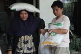 Warga membawa beras dan minyak goreng saat penyaluran Bantuan Pangan di Kantor Kelurahan Polehan, Malang, Jumat (12/12/2025). Penyaluran bantuan dari pemerintah pusat untuk periode OktoberNovember 2025 ini menyasar 20.932 warga penerima manfaat di Kota Malang, dengan setiap keluarga mendapatkan total 20 kg beras dan 4 liter minyak goreng guna meringankan beban pengeluaran rumah tangga serta menjaga ketahanan pangan dan membantu stabilitas harga kebutuhan pokok di pasar. ANTARA Jatim/Ari Bowo Sucipto/mas.