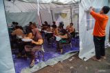 Guru menyiapkan tenda sebelum Asesmen Sumatif Akhir Semester (ASAS) di sekolah darurat bencana erupsi Gunung Semeru di Kecamatan Pronojiwo, Lumajang, Jawa Timur, Sabtu (13/12/2025). Kementerian Pendidikan Dasar dan Menengah (Kemendikdasmen) membangun dua tenda sekolah darurat untuk memfasilitasi 94 siswa SD Negeri 02 Supiturang yang gedung sekolahnya hancur akibat erupsi Gunung Semeru. ANTARA Jatim/Irfan Sumanjaya/mas.