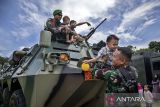 Prajurit TNI Angkatan Darat membantu seorang anak menuruni kendaraan taktis (rantis) panser Anoa usai peringatan Hari Juang TNI AD di di Lapangan Manunggal Brigif 15/Kujang II, Kota Cimahi, Jawa Barat, Senin (15/12/2025). Demonstrasi militer dan parade serta pameran alat utama sistem senjata (alutsista) tersebut digelar dalam rangka memeriahkan peringatan Hari Juang TNI AD yang mengusung tema TNI AD manunggal dengan rakyat untuk Indonesia bersatu, berdaulat, sejahtera dan maju. ANTARA FOTO/Abdan Syakura/agr
