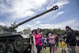 Warga berfoto di depan deretan kendaraan tempur saat pameran alutsista di di Lapangan Manunggal Brigif 15/Kujang II, Kota Cimahi, Jawa Barat, Senin (15/12/2025). Demonstrasi militer dan parade serta pameran alat utama sistem senjata (alutsista) tersebut digelar dalam rangka memeriahkan peringatan Hari Juang TNI AD yang mengusung tema TNI AD manunggal dengan rakyat untuk Indonesia bersatu, berdaulat, sejahtera dan maju. ANTARA FOTO/Abdan Syakura/agr