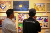 Pengunjung mengamati foto saat gelaran pameran foto jurnalistik dan peluncuran buku Retrospeksi di Kantor LKBN Antara Biro Jawa Timur, Surabaya, Jawa Timur, Selasa (16/12/2025). Pameran foto dan peluncuran buku Retrospeksi yang menampilkan 64 karya pewarta LKBN Antara Jawa Timur itu merupakan rangkaian kegiatan perayaan HUT ke-88 LKBN Antara. Antara Jatim/Tim Dokumentasi Jatim/Um