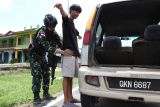 Personel Satgas Pamtas RI-Malaysia Yonarhanud 1/PBC/1 Kostrad melakukan pemeriksaan terhadap pengemudi kendaraan berpelat Malaysia saat melakukan sweeping atau penyisiran di jalan raya Perbatasan Entikong, Kabupaten Sanggau, Kalimantan Barat, Selasa (25/11/2025). Dalam kegiatan tersebut Satgas Pamtas melakukan pemeriksaan terhadap pengendara maupun kendaraan roda dua dan empat yang melintas di kawasan itu guna mencegah peredaran narkotika dan barang ilegal lainnya. ANTARA FOTO/Jessica Wuysang