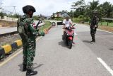 Personel Satgas Pamtas RI-Malaysia Yonarhanud 1/PBC/1 Kostrad bersiaga saat melakukan sweeping atau penyisiran di jalan raya Perbatasan Entikong, Kabupaten Sanggau, Kalimantan Barat, Selasa (25/11/2025). Dalam kegiatan tersebut Satgas Pamtas melakukan pemeriksaan terhadap pengendara maupun kendaraan roda dua dan empat yang melintas di kawasan itu guna mencegah peredaran narkotika dan barang ilegal lainnya. ANTARA FOTO/Jessica Wuysang