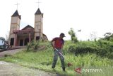 Personel Satgas Pamtas RI-Malaysia Yonarhanud 1/PBC/1 Kostrad menebas rumput menggunakan mesin potong saat melaksanakan karya bhakti di Gereja Katolik Santo Markus Stasi Peripin, Entikong, Kabupaten Sanggau, Kalimantan Barat, Kamis (27/11/2025). Satgas Pamtas RI-Malaysia Yonarhanud 1/PBC/1 Kostrad melaksanakan karya bhakti di gereja sebagai bentuk dukungan terhadap kegiatan keagamaan warga dan mempererat kemanunggalan TNI dengan  masyarakat perbatasan. ANTARA FOTO/Jessica Wuysang