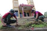Personel Satgas Pamtas RI-Malaysia Yonarhanud 1/PBC/1 Kostrad menebas rumput liar saat melaksanakan karya bhakti di Gereja Katolik Santo Markus Stasi Peripin, Entikong, Kabupaten Sanggau, Kalimantan Barat, Kamis (27/11/2025). Satgas Pamtas RI-Malaysia Yonarhanud 1/PBC/1 Kostrad melaksanakan karya bhakti di gereja sebagai bentuk dukungan terhadap kegiatan keagamaan warga dan mempererat kemanunggalan TNI dengan  masyarakat perbatasan. ANTARA FOTO/Jessica Wuysang