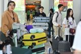 Penumpang pesawat membawa barang bawaan setibanya di Terminal Domestik Bandara Internasional I Gusti Ngurah Rai, Badung, Bali, Rabu (17/12/2025). Pengelola Bandara Bali memprediksi akan melayani sebanyak 1,5 juta orang penumpang selama periode liburan Hari Raya Natal 2025 dan Tahun Baru 2026 dengan perkiraan puncak kepadatan penumpang yang akan terjadi pada Jumat (19/12) mendatang. ANTARA FOTO/Fikri Yusuf/wsj.