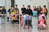 Penumpang pesawat membawa barang bawaan setibanya di Terminal Domestik Bandara Internasional I Gusti Ngurah Rai, Badung, Bali, Rabu (17/12/2025). Pengelola Bandara Bali memprediksi akan melayani sebanyak 1,5 juta orang penumpang selama periode liburan Hari Raya Natal 2025 dan Tahun Baru 2026 dengan perkiraan puncak kepadatan penumpang yang akan terjadi pada Jumat (19/12) mendatang. ANTARA FOTO/Fikri Yusuf/wsj.