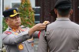 Kapolrestabes Surabaya Kombes Pol Luthfie Sulistiawan menyematkan pita kepada anggota Polri saat apel gelar pasukan Operasi Lilin Semeru 2025 di Polrestabes Surabaya, Surabaya, Jawa Timur, Jumat (19/12/2025). Kepolisian Negara Republik Indonesia (Polri) mengerahkan 146.701 personel gabungan terdiri dari 77.637 anggota Polri, 13.775 anggota TNI, dan 55.289 orang petugas dari pemangku kepentingan terkait lainnya dalam Operasi Lilin 2025 yang berlangsung pada 20 Desembar 2025 hingga 2 Januari 2026 untuk melakukan pengamanan masa Natal 2025 dan Tahun Baru 2026. ANTARA Jatim/Didik Suhartono/mas.