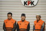 Bupati Bekasi Ade Kuswara Kunang (tengah) bersama ayahnya H.M. Kunang (kanan) dan pihak swasta Sarjan (kiri) dihadirkan saat konferensi pers penahanan usai terjaring operasi tangkap tangan (OTT) di Gedung Merah Putih KPK, Jakarta, Sabtu (20/12/2025). KPK menahan Bupati Bekasi Ade Kuswara Kunang, ayah bupati H. M. Kunang, dan pihak swasta Sarjan setelah ditetapkan tersangka dugaan tindak pidana korupsi terkait suap ijon proyek di Kabupaten Bekasi. ANTARA FOTO/Hafidz Mubarak A/rwa.