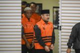 Bupati Bekasi Ade Kuswara Kunang bersama ayahnya H. M. Kunang (kiri) dan pihak swasta Sarjan (kedua kiri) dihadirkan saat konferensi pers penahanan usai terjaring operasi tangkap tangan (OTT) di Gedung Merah Putih KPK, Jakarta, Sabtu (20/12/2025). KPK menahan Bupati Bekasi Ade Kuswara Kunang, ayah bupati H. M. Kunang, dan pihak swasta Sarjan setelah ditetapkan tersangka dugaan tindak pidana korupsi terkait suap ijon proyek di Kabupaten Bekasi. ANTARA FOTO/Hafidz Mubarak A/rwa. 