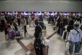 Calon penumpang pesawat antre di area lapor diri sebelum melakukan penerbangan di Bandara Internasional Juanda Surabaya di Sidoarjo, Jawa Timur, Senin (22/12/2025). Berdasarkan data statistik yang dirilis pihak bandara, selama awal pembukaan Posko Pelayanan Natal 2025 dan Tahun Baru 2026 (Nataru) jumlah penumpang menembus 158 ribu orang dan 1.106 pergerakan pesawat. Antara Jatim/Umarul Faruq