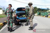 Dua personel Satgas Pamtas RI-Malaysia Yonarhanud 1/PBC/1 Kostrad bersama personel Tentara Diraja Malaysia (TDM) memeriksa kendaraan berpelat Malaysia di Jalan Lintas Negara Malindo, Entikong, Kabupaten Sanggau, Kamis (27/11/2025). Pemeriksaan yang dilaksanakan Satgas Pamtas Yonarhanud 1/PBC/1 Kostrad tersebut bertujuan mengantisipasi berbagai aktivitas ilegal, termasuk peredaran narkotika, masuknya barang ekspor tanpa melalui jalur resmi, serta praktik perdagangan manusia. ANTARA FOTO/Jessica Wuysang