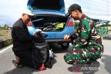 Personel Satgas Pamtas RI-Malaysia Yonarhanud 1/PBC/1 Kostrad memeriksa barang bawaan pengendara berpelat Malaysia saat pemeriksaan kendaraan di Jalan Lintas Negara Malindo, Entikong, Kabupaten Sanggau, Kamis (27/11/2025). Pemeriksaan yang dilaksanakan Satgas Pamtas Yonarhanud 1/PBC/1 Kostrad tersebut bertujuan mengantisipasi berbagai aktivitas ilegal, termasuk peredaran narkotika, masuknya barang ekspor tanpa melalui jalur resmi, serta praktik perdagangan manusia. ANTARA FOTO/Jessica Wuysang