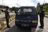 Dua personel Satgas Pamtas RI-Malaysia Yonarhanud 1/PBC/1 Kostrad menyapa warga saat menggelar pemeriksaan kendaraan di Jalan Lintas Negara Malindo, Entikong, Kabupaten Sanggau, Kamis (27/11/2025). Pemeriksaan yang dilaksanakan Satgas Pamtas Yonarhanud 1/PBC/1 Kostrad tersebut bertujuan mengantisipasi berbagai aktivitas ilegal, termasuk peredaran narkotika, masuknya barang ekspor tanpa melalui jalur resmi, serta praktik perdagangan manusia. ANTARA FOTO/Jessica Wuysang