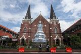 Warga mengamati pohon Natal di Gereja Katolik Kelahiran Santa Perawan Maria, Jalan Kepanjen, Surabaya, Jawa Timur, Senin (22/12/2025). Pohon Natal yang dibuat dari ratusan botol plastik bekas berbagai ukuran dan memiliki tinggi 12 meter itu untuk menyambut Hari Natal 2025. ANTARA Jatim/Didik Suhartono/mas.