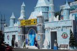Sejumlah masyarakat swafoto di depan Pos Pelayanan pengamanan Natal 2025 dan Tahun Baru 2026 bertema 'Frozen' Disneyland di simpang empat Jalan KH A Wahid Hasyim Kabupaten Jombang, Jawa Timur, Selasa (23/12/2025). Pos pelayanan (posyan) yang dibangun Satuan Lalu Lintas Polres Jombang ini sengaja dirancang ramah keluarga, dan selama libur Natal 2025 dan Tahun Baru 2026 Polres setempat mendirikan enam pos pengamanan dan pelayanan untuk memastikan situasi kamtibmas tetap aman. Antara Jatim/Syaiful Arif/um