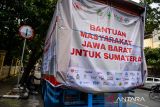Petugas memasang spanduk bantuan masyarakat Jawa Barat sebelum diberangkatkan di Bandung, Jawa Barat, Selasa (23/12/2025). Pemerintah Provinsi Jawa Barat bersama Kantor Wilayah Kementerian Agama Jawa Barat dan lembaga bantuan amal menyalurkan bantuan kebutuhan pokok senilai Rp6 milliar untuk korban bencana di tiga provinsi di Pulau Sumatera. ANTARA FOTO/Raisan Al Farisi/agr
