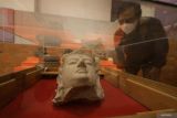 Seorang pengunjung mengamati kepala arca saat pembukaan Museum Sri Aji Joyoboyo, Kabupaten Kediri, Jawa Timur, Kamis (25/12/2025). Museum baru milik Pemkab Kediri tersebut dibuka secara terbatas dengan menampilkan 50 artefak dari total koleksi sebanyak 190 artefak arkeologi peninggalan era pra Kerajaan Kediri hingga masa kolonial Belanda. Antara Jatim/Prasetia Fauzani/um
